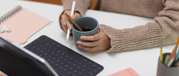 A close-up image of a mentor giving guidance to a young entrepreneur in a co-working space, both focused on a laptop screen, with sticky notes and a cup of coffee on the table.