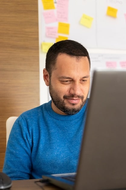 Image of a Mexican entrepreneur mentoring a young startup founder in a co-working space, both looking at a laptop screen with a collaborative and supportive expression.