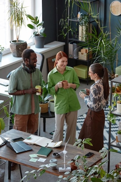 A picture of a group of diverse entrepreneurs gathered around a table, brainstorming ideas for a sustainable business. The setting is a modern office with large windows and plants.
