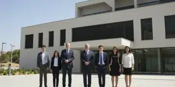 Familia empresarial española de varias generaciones frente a su sede, simbolizando la continuidad.